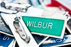 Green Name Tag Spelling Wilbur Amongst Pile of Badges
