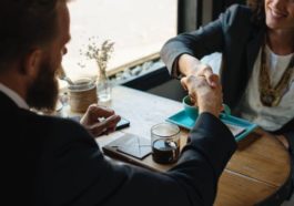 Man and woman shake hands in business meeting for success