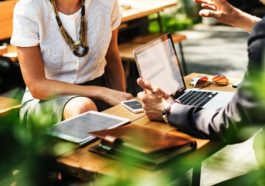 Man and woman conducting a small business meeting at an outdoor cafe